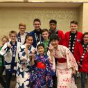 Mitglieder des Göttinger Knabenchors in japanischen Wickeljakcen und des Kinderchors von Tokushima in bunten Kimonos lächeln in fröhlich in die Kamera