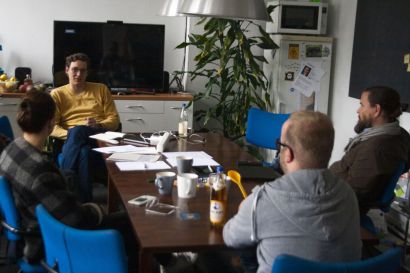 Mitglieder der Entwickleragentur CoWAIN und kulturis-Projektleiter Moritz Steinhauer sitzen an einem Konferenztisch und tauschen sich aus.