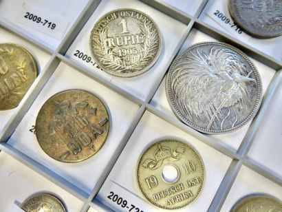Eine Sammlung deutscher Kolonialmünzen im Museum Hann. Münden. Verschiedene Münzen liegen in einem Kasten mit Fächern und Inventarnummern (Foto: C. Riemenschneider)