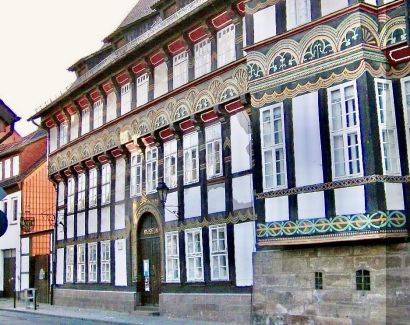 Ansicht des dreistöckigen Fachwerkgebäudes mit bunt bemalten gotischen Schnitzereien