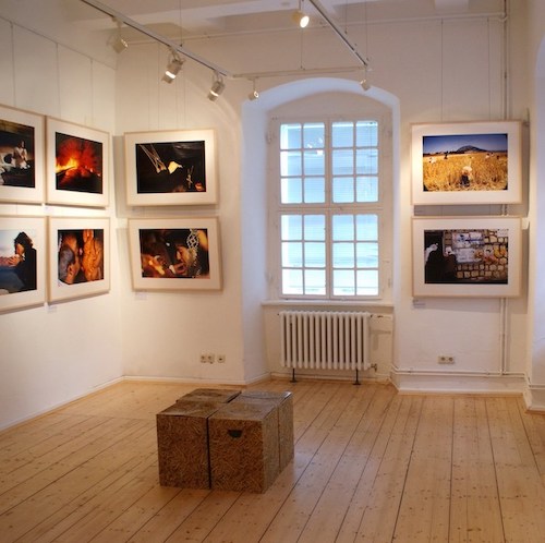 In einem Ausstellungsraum hängen großformatige Farbfotografien mit unterschiedlichen Motiven rund um das Thema Brot.